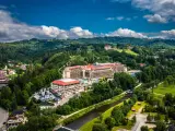 Widok z lotu ptaka na Hotel Gołębiewski w otoczeniu zielonych wzgórz i rzeki.