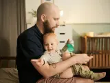 Ojciec z dzieckiem na rękach, czas spędzony razem to najlepszy urlop wychowawczy, lepszy niż urlop wypoczynkowy.