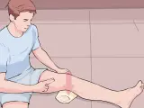 Mann mit einem Handtuch unter dem Knie, der auf eine Schwellung zeigt. Möglicherweise eine Bakerzyste, die mit Liebscher & Bracht behandelt wird.