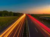 Ljusspår av bilar på en tysk autobahn vid solnedgången.