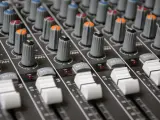Regler und Fader eines Mischpults, bereit, um zu lernen, wie man Musik mixt.
