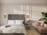Elegancka sypialnia z łóżkiem, różową sofą i rośliną.