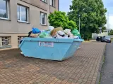 Kontener na śmieci pełen worków i odpadów, z napisem "Przyjazny Recykling". Data: 16 02 14.