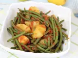 Fagiolini in umido con patate, un piatto saporito e colorato, servito in una ciotola bianca su una tovaglia a quadri.