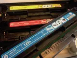 W drukarce widoczne są kolorowe tonery HP LaserJet 128A. Po zużyciu, tonery te wymagają odpowiedniego postępowania, zgodnie z kodem odpadu.