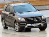 Brązowy Mercedes-Benz ML na mokrej nawierzchni, z widoczną tablicą rejestracyjną WW 0537T.