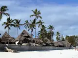 Rajskie plaże Zanzibaru, palmy i domki z krytymi strzechą dachami. Przed wyjazdem warto pomyśleć o zanzibar szczepienia.