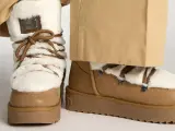 Botas de invierno marrones con forro de pelo blanco y cordones. Perfectas para limpiar y mantenerlas impecables.