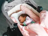 Słodki sen noworodka w wózku, kiedy pierwszy spacer z noworodkiem to magiczny moment.