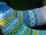 Två par stickade sockor med färgglatt sticka mönster med två färger i blått, gult, grönt och vitt.