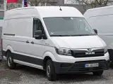 Biały MAN TGE 3.180 stoi na żwirze, gotowy do pracy.