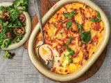En krämig kasslergratäng med ost och örter, serverad med en fräsch sallad. Ett perfekt kassler recept för middagen.