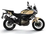 Beżowy motocykl turystyczny z bagażnikami, gotowy na dalekie wyprawy.