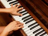 Dłonie grające na pianinie, tworząc muzyczną progresję.
