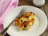 Brotpudding mit Rosinen auf einem Teller mit einer Gabel und einer rosa karierten Serviette.