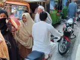 Ludzie na ulicy w Pakistanie, wśród nich kobiety w hidżabach i dzieci. Czy pakistan jest bezpieczny? Tłum na targu, ruchliwa ulica.