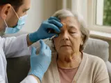 Medico con guanti esegue iniezioni intravitreali a un'anziana. Valutare attentamente le iniezioni intravitreali controindicazioni prima del trattamento.