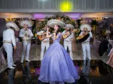 Mariachi grają, a dziewczyna w fioletowej sukni posyła całusy. W tle weselne dekoracje i goście. Idealna sceneria do przyśpiewki weselne tekst.