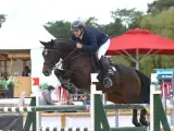 Cavalier et cheval sautant un obstacle lors des jeux équestres mondiaux.