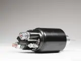 A black starter solenoid with copper and silver bolts, ready to power up an engine.