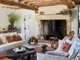 Accogliente soggiorno con camino in pietra, travi a vista e arredi che evocano idee case di campagna interni.