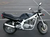 Czarny motocykl Suzuki GS 500, idealny do miasta. Poznaj jego dane techniczne i poczuj wolność na drodze.