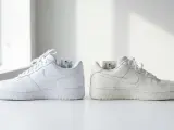 Dwa białe buty Nike Air Force 1, jeden świeży, drugi lekko przybrudzony. Czy 50 style ma oryginalne buty? Metki z kodami sugerują autentyczność.