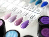 Paleta próbek lakierów do paznokci w odcieniach fioletu i różu, z etykietami jak "Berry Flavor". Obok stoją słoiczki z lakierami, jeden z nich ma napis "neoneil".