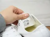 Porównanie converse oryginalne a podróbki. Dłoń pokazuje metkę z rozmiarem na białym bucie.