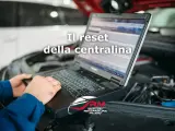 Tecnico esegue il reset centralina auto con laptop. Il logo RM Servizio Rimappatura Milano è visibile.