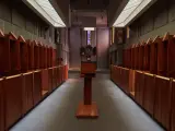 Rows of wooden stalls line the interior of a Carthusian monastery, leading towards an altar.
