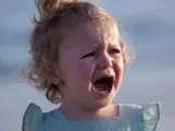 Ein kleines Mädchen mit blonden Locken weint bitterlich. Tränen laufen über ihre Wangen. Wahrscheinlich ist sie mitten in der Trotzphase mit 2 Jahren.