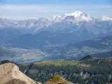 Vue panoramique des Alpes, avec le Mont Blanc enneigé, point culminant des Alpes, dominant la vallée verdoyante et ses villages.