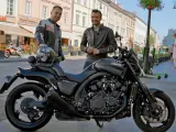 Dwóch mężczyzn pozuje obok czarnego motocykla Yamaha V-Max 1700 na ulicy.