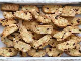 Un vassoio pieno di croccanti biscotti toscani, ricchi di mandorle e mirtilli rossi, pronti per essere inzuppati.