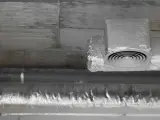 Izolowane rury wentylacyjne z okrągłym nawiewnikiem pod betonowym sufitem.
