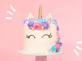 Magisk enhörningstårta med horn och öron, dekorerad med färgglad frosting. Ett perfekt unicorn tårta recept för kalaset!