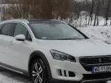 Biały Peugeot 508 RXH na śniegu, gotowy na zimowe wyzwania.