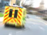 Ambulans w ruchu na drodze, z widocznym napisem AMBULANCE.
