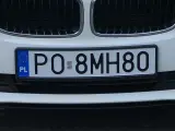 Białe BMW z tablicą rejestracyjną PO 8MH80.