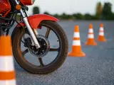Czerwony motocykl i pomarańczowe pachołki na placu manewrowym. Przygotowanie do egzaminu na kategorie prawa jazdy na motor.