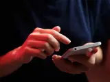 Dłonie z czerwonym podświetleniem obsługują smartfon, być może ustawiając **direct debit** na rachunki.