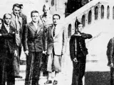 Groupe d'hommes en costume, dont Henri Frenay et François Mitterrand, posant devant un escalier.