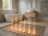 Installation d'un système de chauffage au sol dans une salle de bain moderne. Des tubes orange sont posés sur le béton, prêts à diffuser une chaleur confortable.
