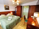 Przytulny pokój hotelowy z dużym łóżkiem, szafą i biurkiem. Czy żeby wynająć pokój w hotelu trzeba mieć 18 lat?