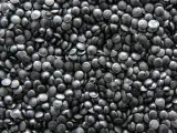 Mnóstwo czarnych granulek regranulatu HDPE, gotowych do przetworzenia w nowe produkty.