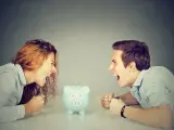 Un couple se crie dessus, poings serrés, devant une tirelire. Un vrai vol entre époux, la dispute pour l'argent est intense.