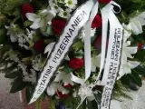 Wieniec pogrzebowy z białymi liliami i czerwonymi różami. Napis na szarfie: "Z ostatnim pożegnaniem od koleżanki i kolegów z Komendy Miejskiej Policji w Olsztynie".