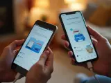 Dwie osoby trzymają telefony połączone kablem. Na ekranach widnieje instrukcja, jak przenieść dane z telefonu na telefon za pomocą aplikacji Smart Switch.