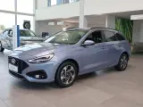 Niebieski Hyundai i30 Wagon z 2015 roku stoi w salonie samochodowym.